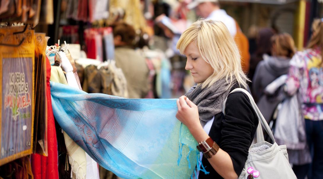 A participant explores a local market as part of her ethical consumerism project abroad. Woman learns about ethical consumerism on a trip abroad.